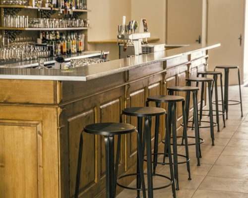 mobilier bar horeca din lemn cu blat metalic și scaune de bar într-un spațiu clasic